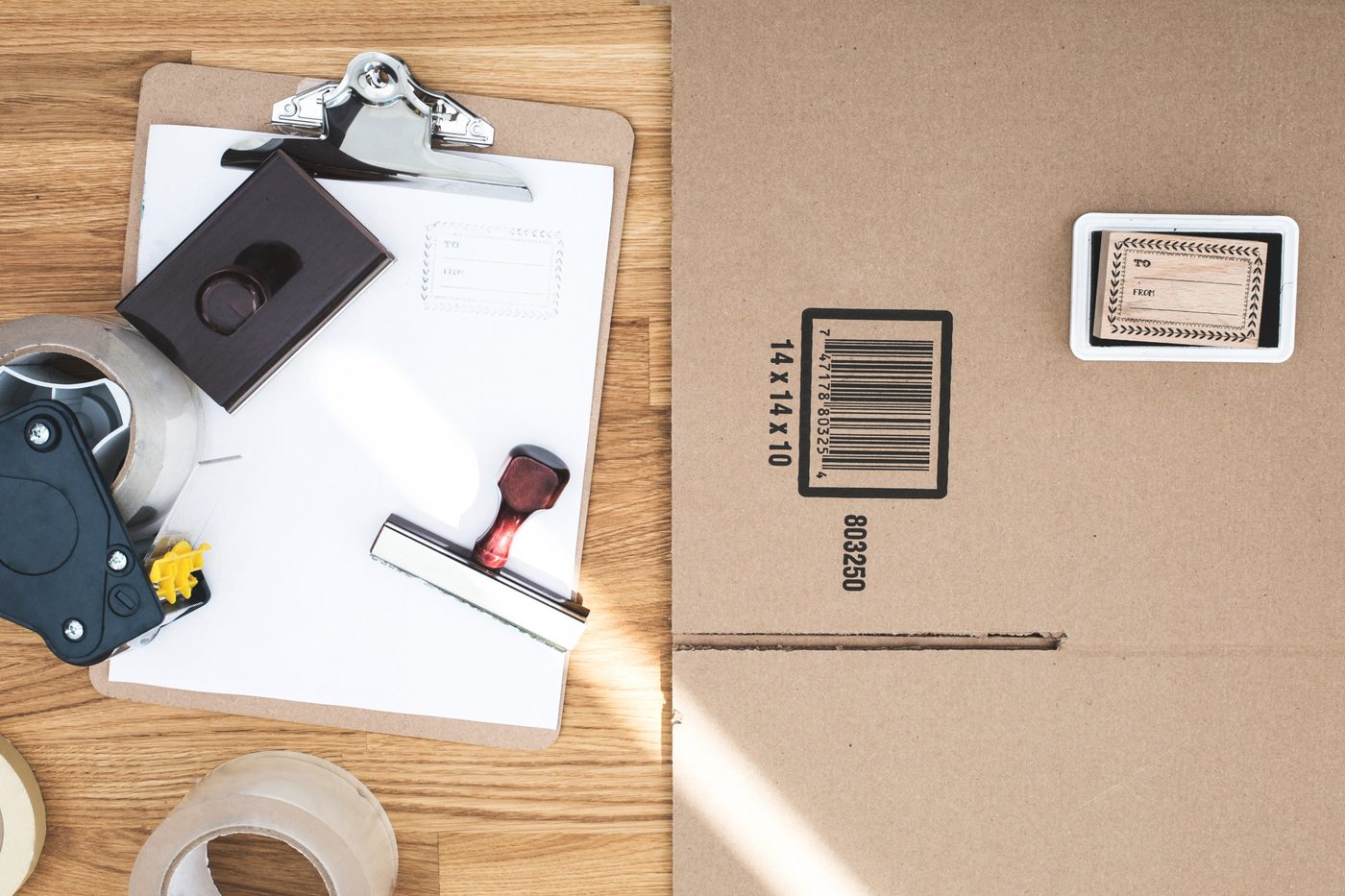 Versandkarton, Klebeband, Stempel und Verpackungsmaterial als Symbol für Versand, Retouren und Shop-Alltag